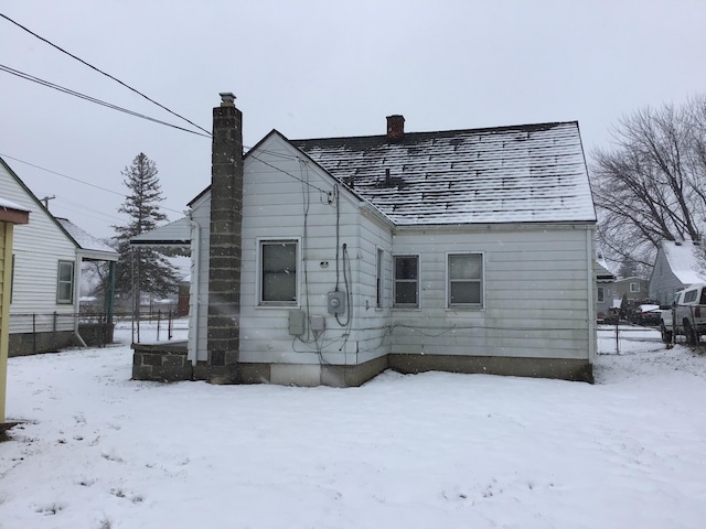 19595 Waldron St, Roseville, MI 48066 - snow covered rear of property with a chimney and fence