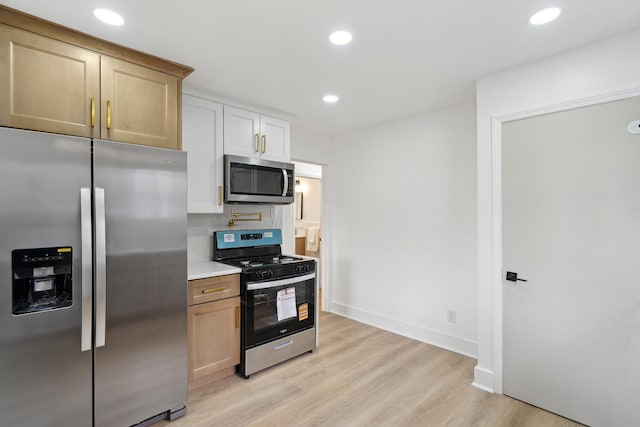 kitchen with appliances with stainless steel finishes, light countertops, light wood-type flooring, recessed lighting, and baseboards
