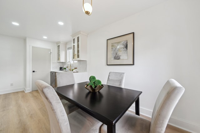 dining room with light wood-type flooring, baseboards, and recessed lighting