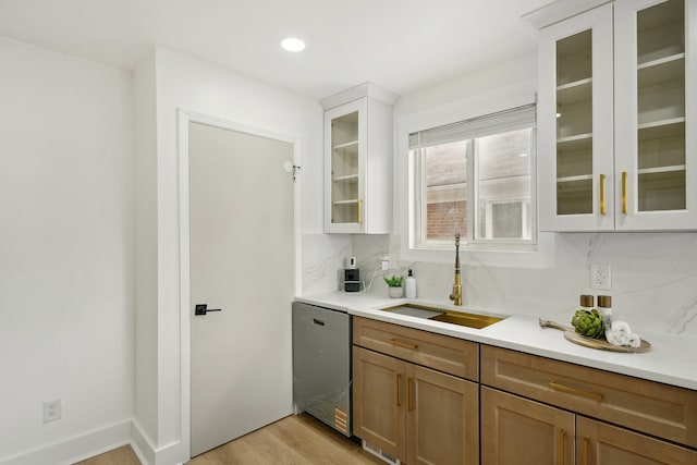 bar area featuring a sink, dishwasher, tasteful backsplash, light wood-style flooring, and recessed lighting