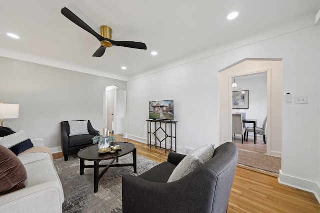 living room featuring a ceiling fan, light wood finished floors, recessed lighting, and baseboards
