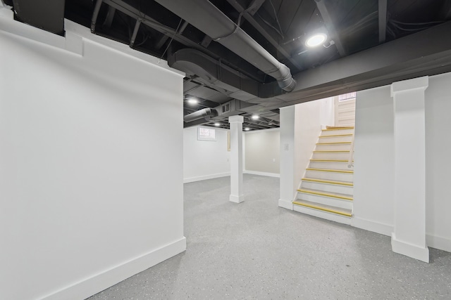finished basement featuring baseboards and stairs