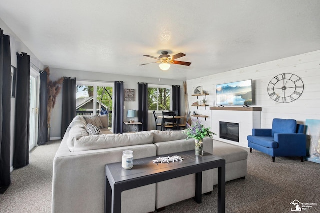 3131 Morin Point St, Erie, MI 48133 - living room featuring carpet flooring, ceiling fan, a glass covered fireplace, and wooden walls