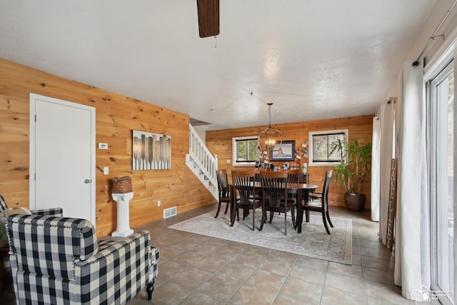 3131 Morin Point St, Erie, MI 48133 - dining space with wooden walls, light tile patterned floors, and stairs