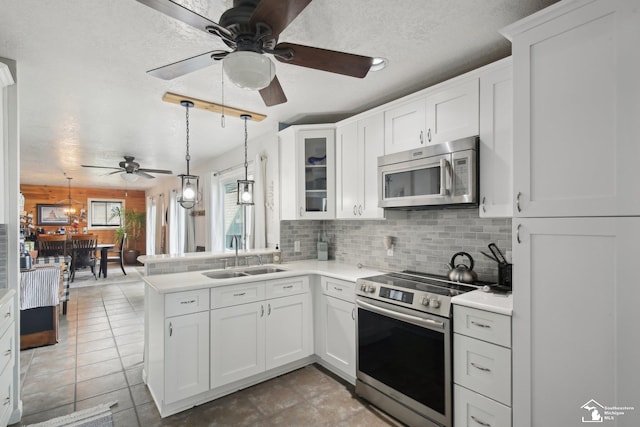 3131 Morin Point St, Erie, MI 48133 - kitchen featuring appliances with stainless steel finishes, a sink, a ceiling fan, decorative backsplash, and a peninsula