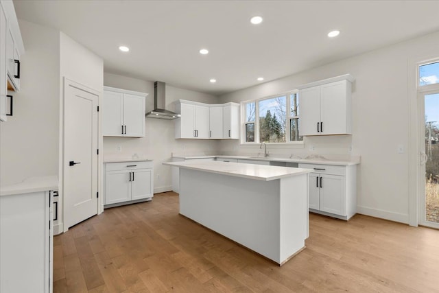6514 Cambridge Cir, Clarkston, MI 48346 - kitchen with wall chimney exhaust hood, a sink, light wood-type flooring, healthy amount of natural light, and recessed lighting