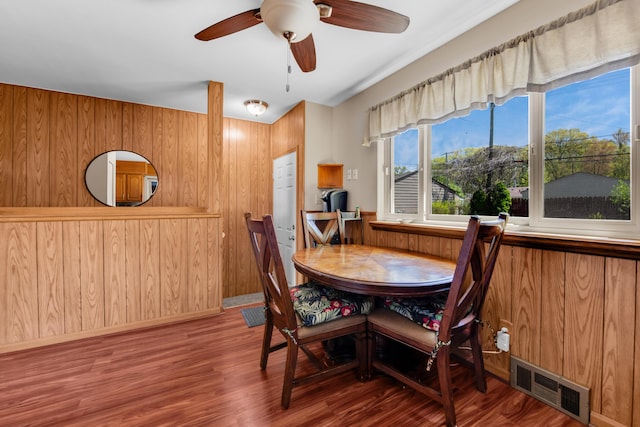 33945 Birchwood St, Westland, MI 48186 - dining room featuring wood finished floors, wooden walls, ceiling fan, and baseboards