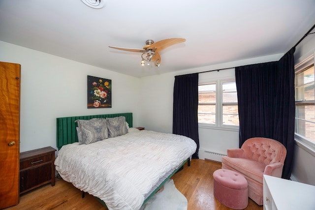 1066 Knight Rd, Ann Arbor, MI 48103 - bedroom with baseboard heating, wood finished floors, and multiple windows