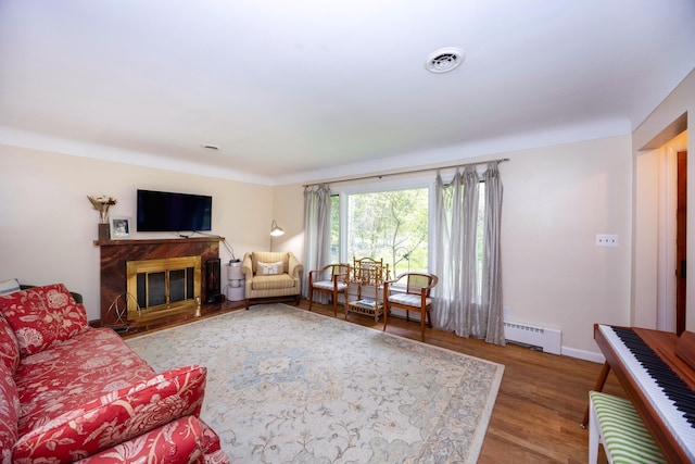 1066 Knight Rd, Ann Arbor, MI 48103 - living room featuring wood finished floors, baseboard heating, baseboards, and a high end fireplace