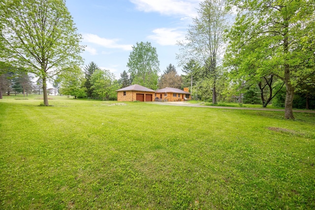 1066 Knight Rd, Ann Arbor, MI 48103 - view of green lawn with a garage and driveway