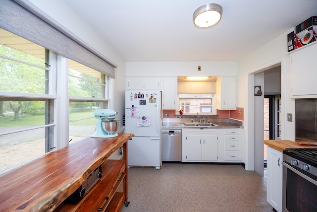 1066 Knight Rd, Ann Arbor, MI 48103 - kitchen featuring appliances with stainless steel finishes, stainless steel countertops, a sink, and white cabinetry