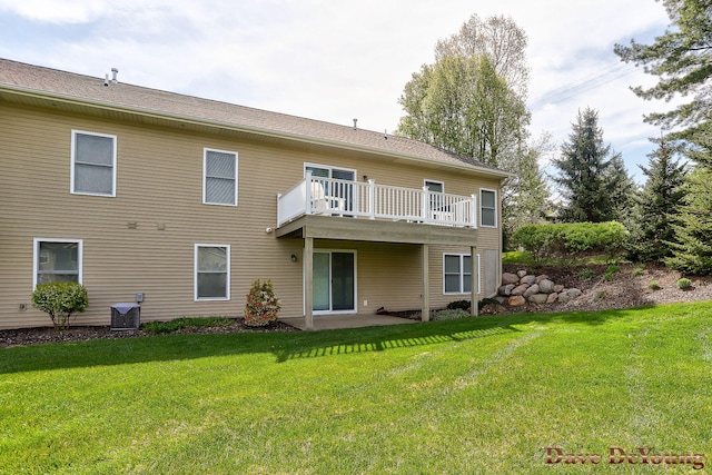 back of property featuring a lawn and central AC