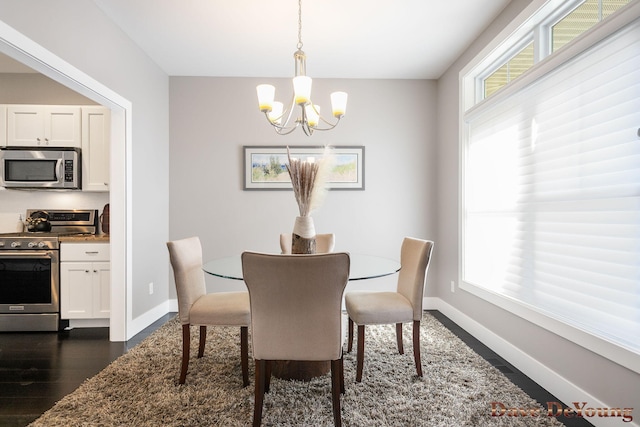 dining room with a chandelier, baseboards, and dark wood-style flooring