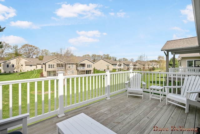 wooden terrace featuring a residential view and a yard