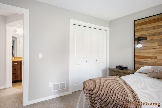 bedroom with light carpet, a closet, and baseboards