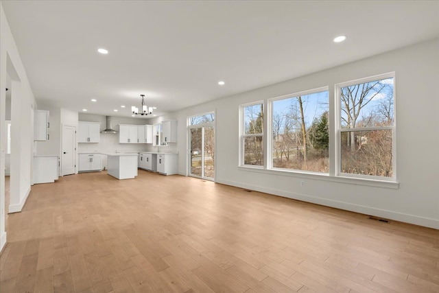 6515 Cambridge Cir, Clarkston, MI 48346 - unfurnished living room with a chandelier, baseboards, recessed lighting, and plenty of natural light