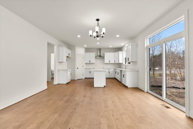 6515 Cambridge Cir, Clarkston, MI 48346 - kitchen with wall chimney range hood, a chandelier, a sink, a center island, and light wood-type flooring