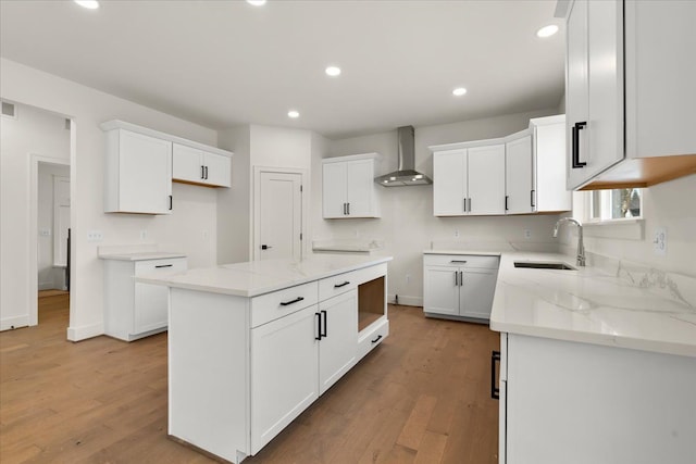 6515 Cambridge Cir, Clarkston, MI 48346 - kitchen featuring wall chimney range hood, wood finished floors, light stone countertops, a sink, and recessed lighting