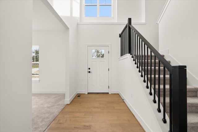 6515 Cambridge Cir, Clarkston, MI 48346 - entrance foyer with light wood-style floors, a high ceiling, stairs, and baseboards