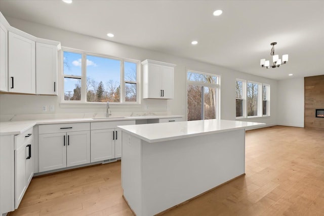 6515 Cambridge Cir, Clarkston, MI 48346 - kitchen with a sink, a chandelier, light wood-style flooring, recessed lighting, and white cabinetry