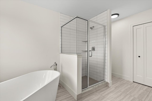 6515 Cambridge Cir, Clarkston, MI 48346 - bathroom featuring a shower stall, a soaking tub, and baseboards