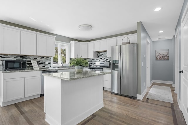 19101 Weller Rd, Gregory, MI 48137 - kitchen with appliances with stainless steel finishes, backsplash, white cabinetry, wood finished floors, and recessed lighting
