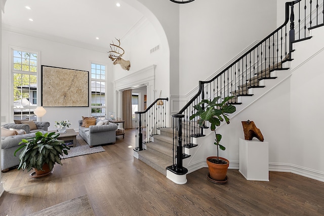 entrance foyer featuring plenty of natural light, arched walkways, wood finished floors, recessed lighting, and ornamental molding