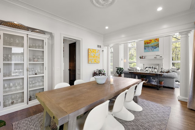 dining space with decorative columns, crown molding, dark wood finished floors, and recessed lighting