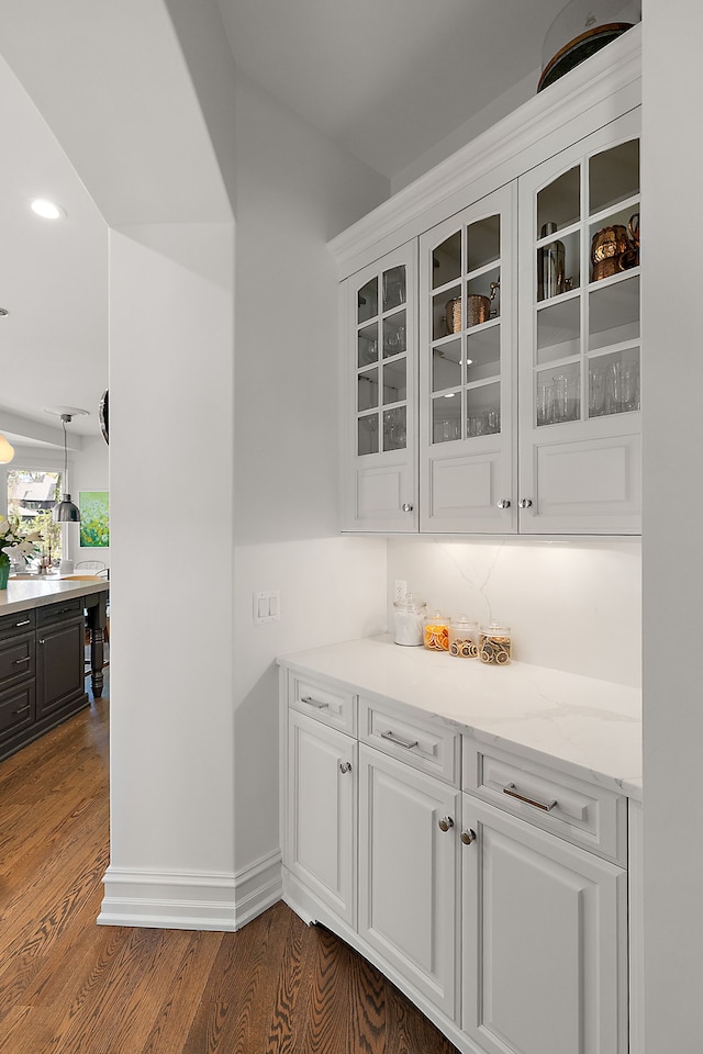 bar area with dark wood finished floors, recessed lighting, and baseboards