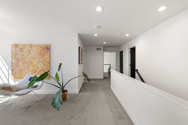 hall with carpet flooring, recessed lighting, baseboards, and an upstairs landing