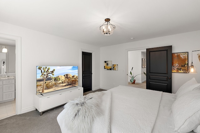 bedroom with carpet, ensuite bath, baseboards, a sink, and a chandelier