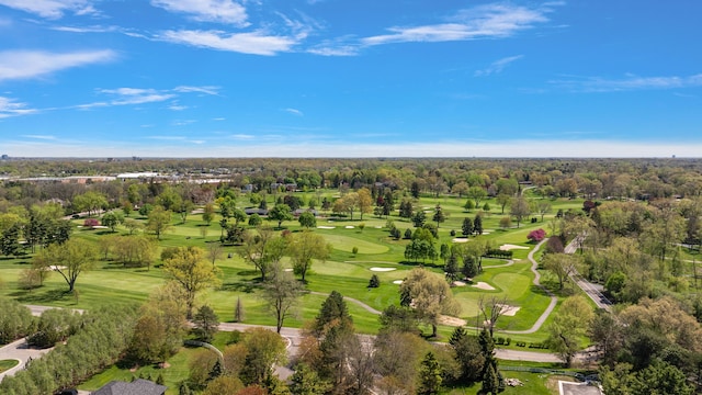 drone / aerial view of a golf club and a tree filled landscape