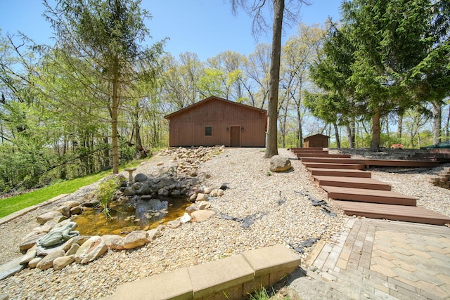 3380 Norvell Rd, Grass Lake, MI 49240 - view of home's exterior with an outdoor structure and a garden pond