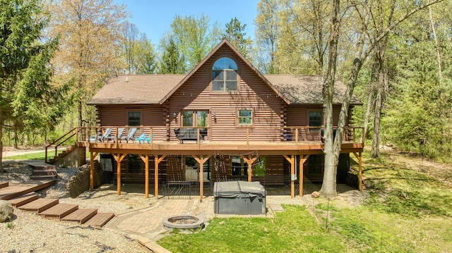 3380 Norvell Rd, Grass Lake, MI 49240 - back of property featuring a hot tub, a wooden deck, log siding, stairway, and a fire pit