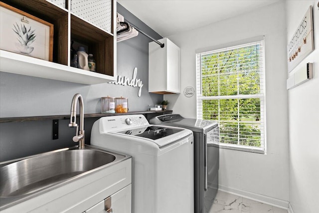2694 Driftwood Dr, Waterford, MI 48329 - washroom featuring cabinet space, washer and dryer, light marble finish flooring, baseboards, and healthy amount of natural light