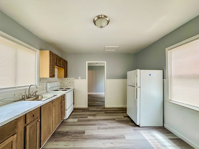 4226 Cadillac Ave, Wayne, MI 48184 - kitchen with white appliances, a sink, light wood finished floors, and brown cabinets