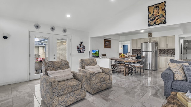 living room featuring french doors, light marble finish floors, recessed lighting, and lofted ceiling