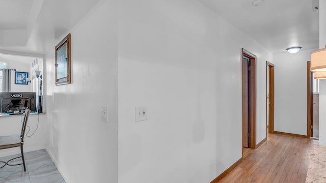 hall featuring baseboards and light wood-style floors