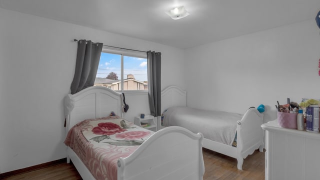 bedroom featuring wood finished floors and baseboards