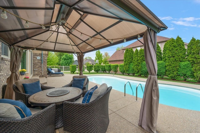 view of swimming pool with a gazebo, a patio area, and fence