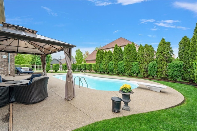 view of swimming pool with a gazebo, a patio, a diving board, and fence