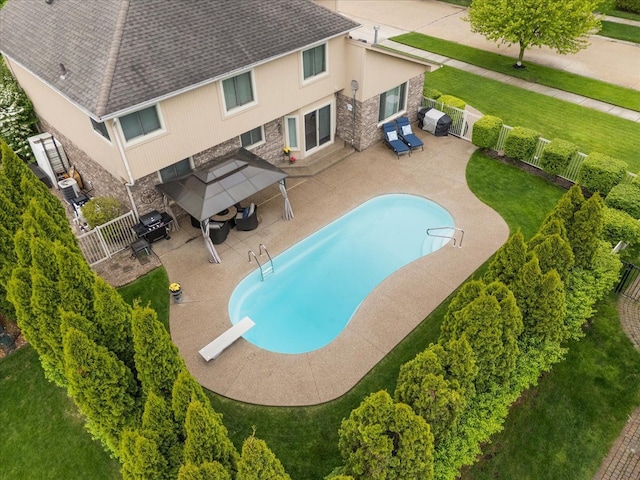 view of pool featuring a fenced backyard, a patio area, and a diving board
