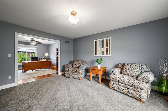 sitting room featuring an office area, carpet floors, baseboards, and a ceiling fan