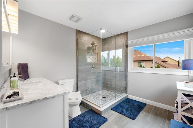 full bath with a stall shower, toilet, vanity, and baseboards