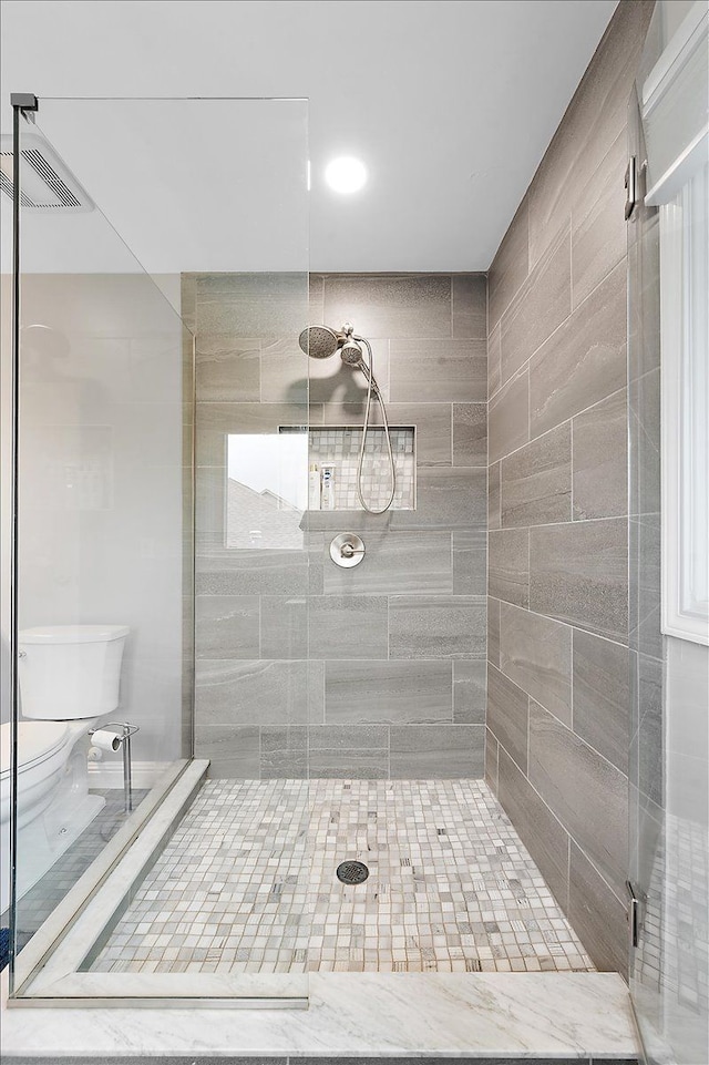 full bathroom with a shower stall and toilet