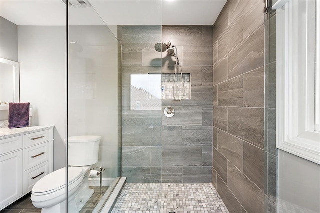 bathroom with toilet, walk in shower, and vanity