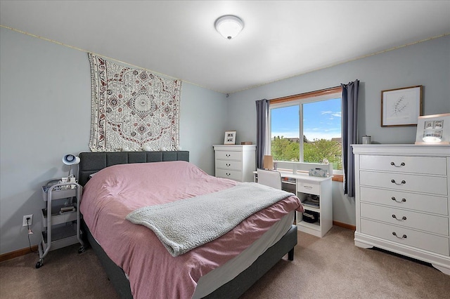 bedroom featuring light colored carpet and baseboards
