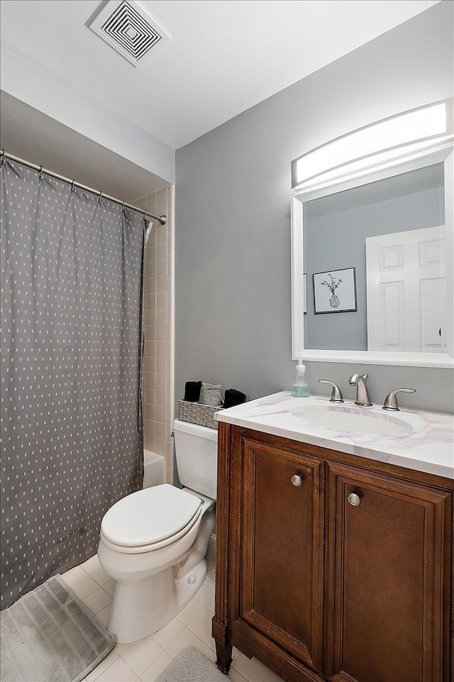 bathroom featuring tile patterned flooring, toilet, vanity, and shower / bath combo with shower curtain