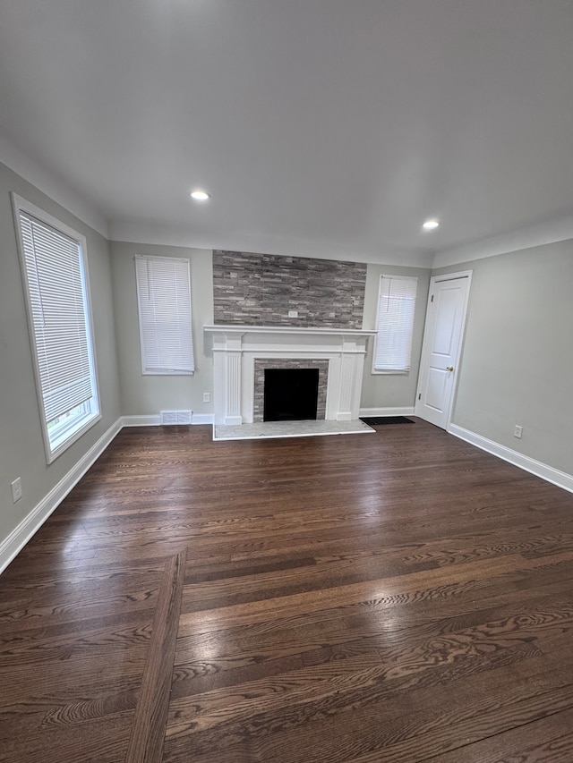 unfurnished living room featuring a fireplace, recessed lighting, baseboards, and plenty of natural light