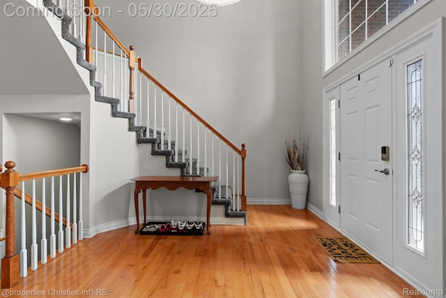 24516 Cavendish Ave E, Novi, MI 48375 - foyer entrance featuring a towering ceiling, wood-type flooring, plenty of natural light, and baseboards